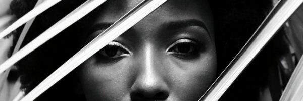 pexels-photo-2049171-2049171 Elegant black and white portrait of a woman behind leaves, capturing natural beauty.