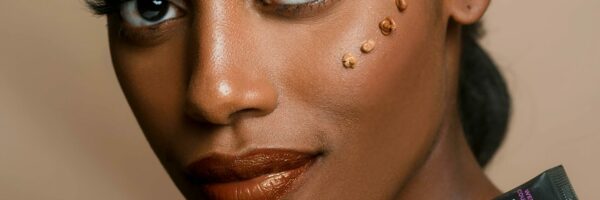 pexels-photo-2661256-2661256 Elegant portrait of a woman showcasing skincare product with flawless makeup and glowing skin.